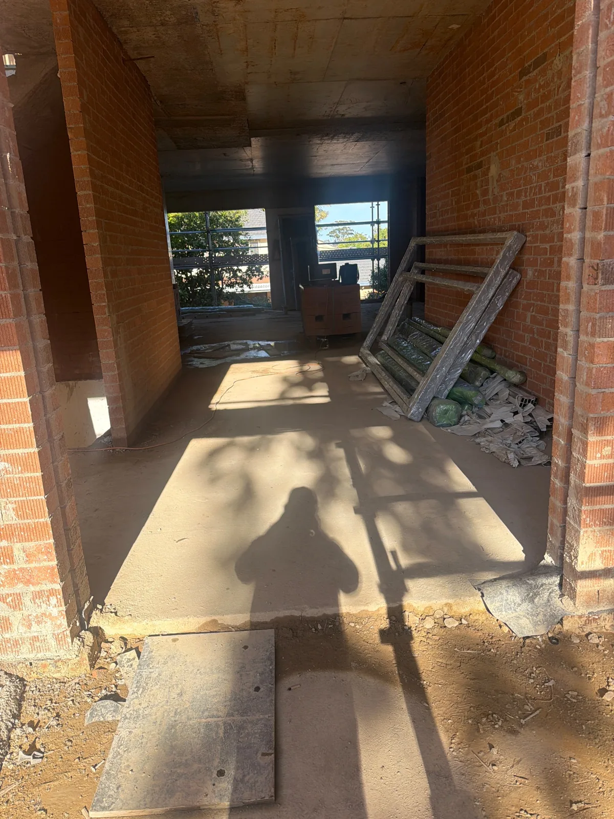 Interior brick walls and stored window or door components at 10 College Crescent · 2026-09-30