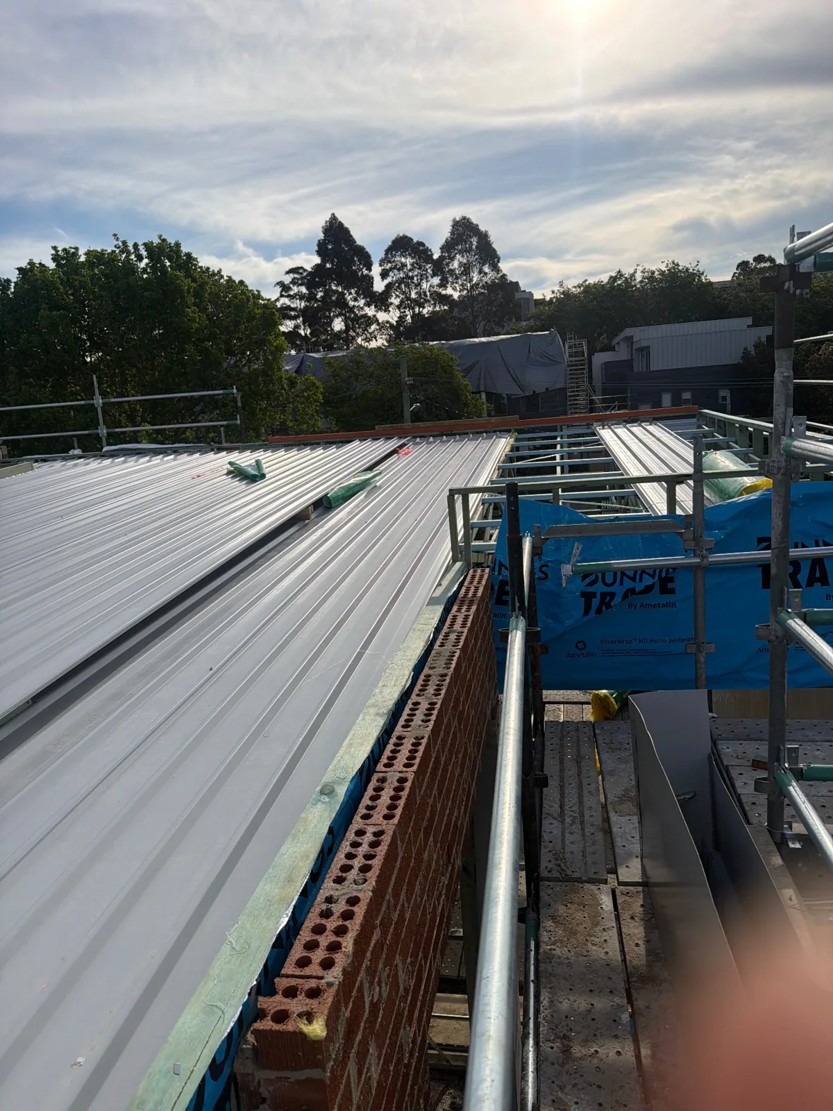 Partially covered metal roof and open skylight framing at 10 College Crescent · 2026-10-01