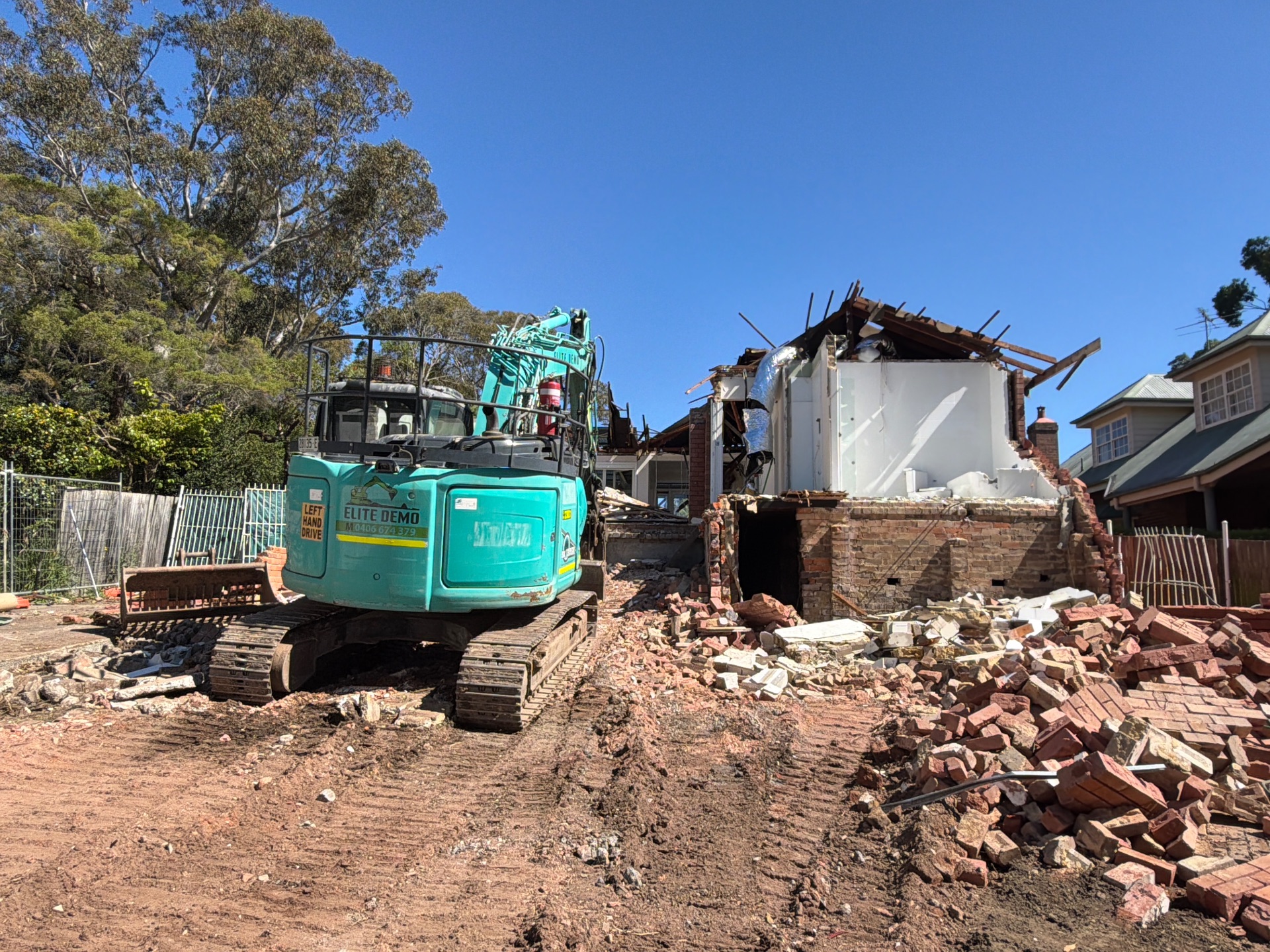 Excavator, partially demolished structure and debris at 9 Barons Crescent.